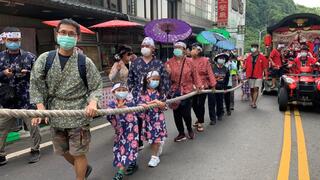 People attend  pulling float with mask