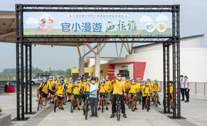 The director of Siraya National Scenic Area Administration and the principal of Tainan Municipal Guantian District Guantian Elementary School take photos with students before cycling