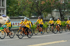 生徒たちが自転車に乗って官田小学校の門口に通過する