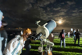 Visitor stargazing the moon through high power telescope